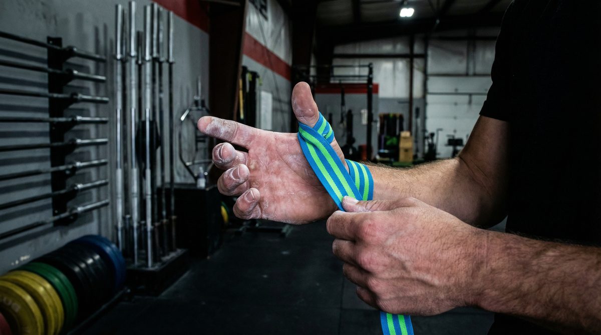 Athlete wrapping thumb tape before a heavy lift at a CrossFit gym