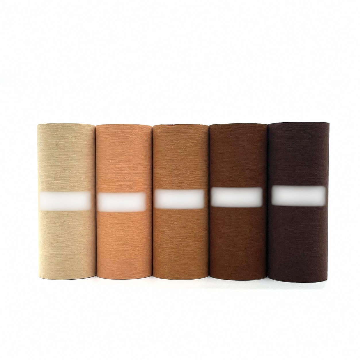 Five rolls of wide cotton kinesiology tape in a full range of skin tones from lightest beige to darkest espresso brown