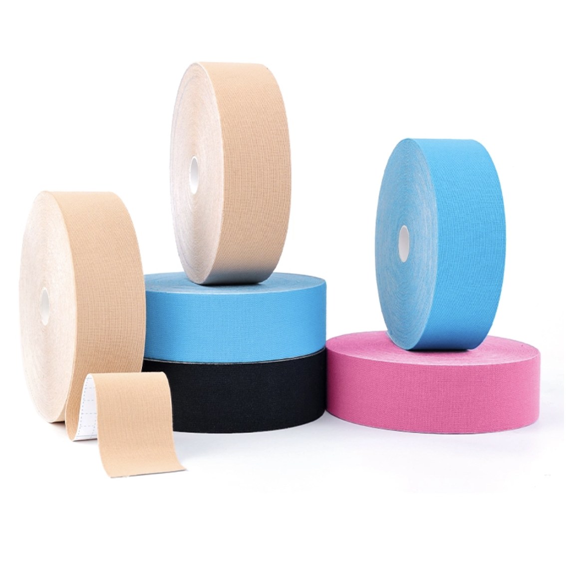 Multiple colors of bulk kinesiology tape rolls — beige, blue, black, pink arranged together