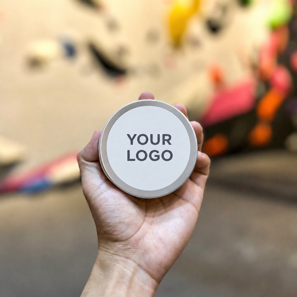 Custom branded finger tape tin held at a climbing gym — OEM private label product